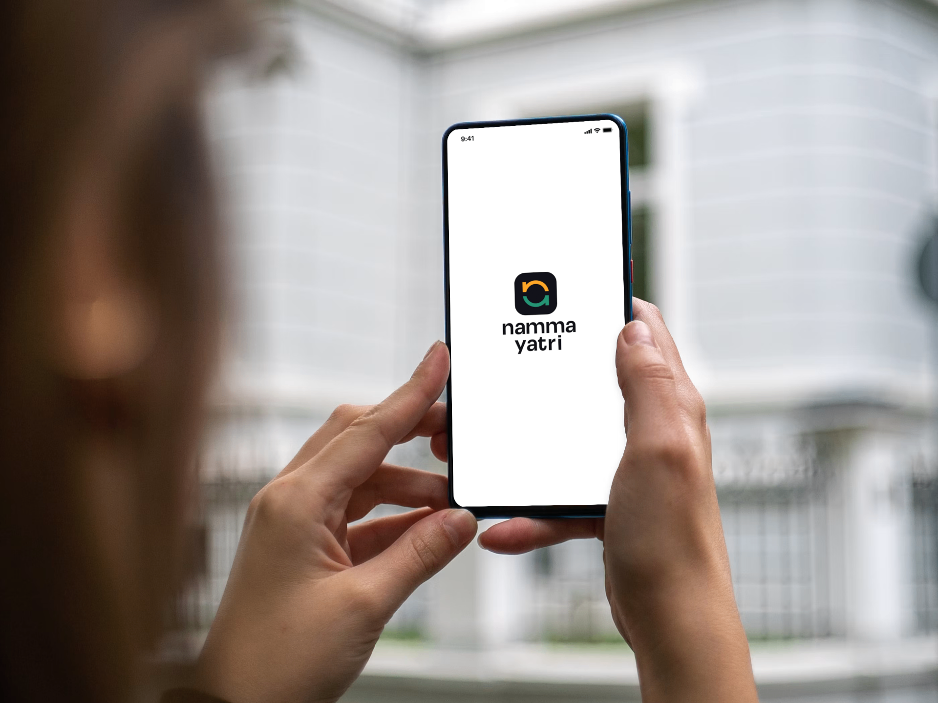 A person holding a smartphone displaying the Namma Yatri app splash screen.